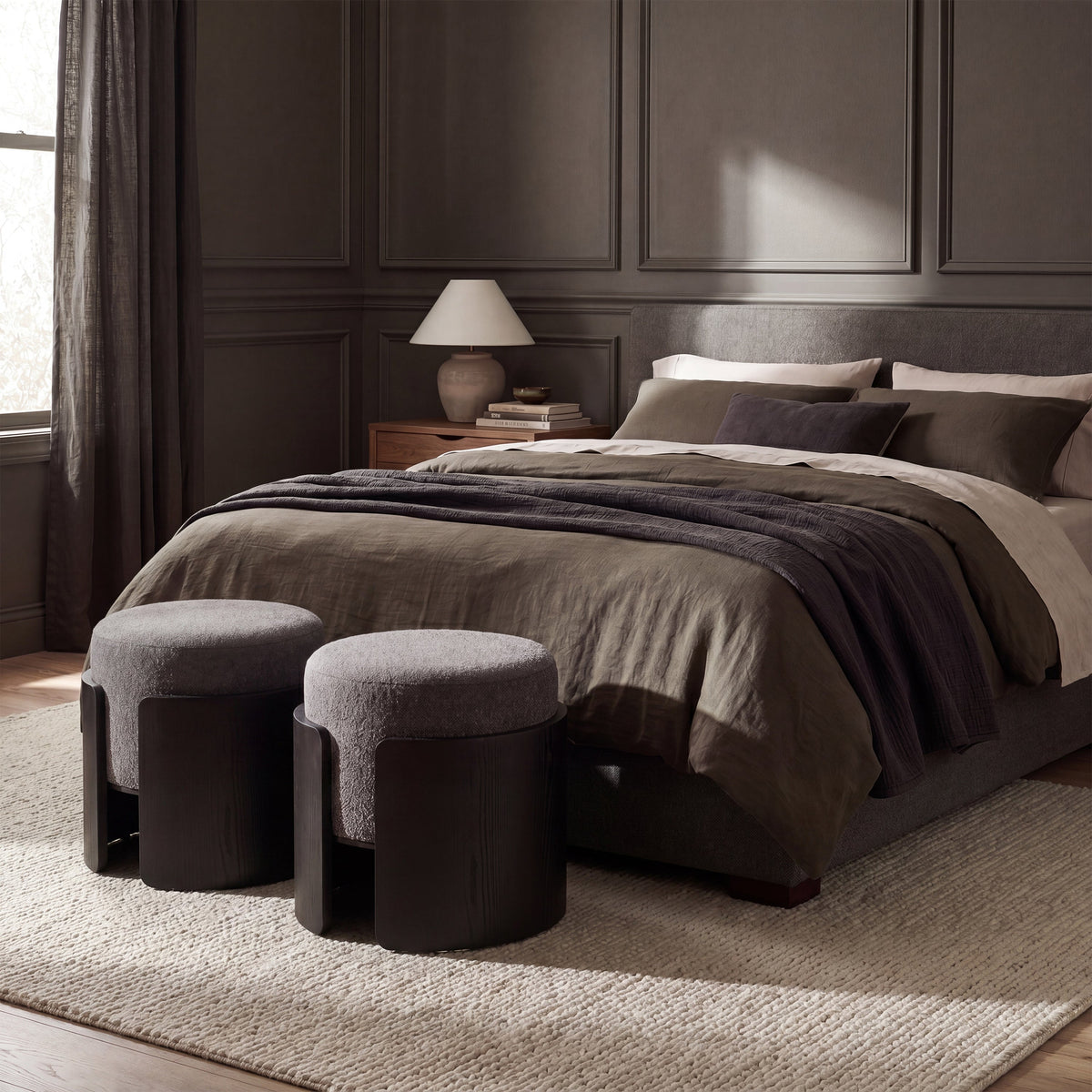 Capsula upholstered ottoman in black, styled in a room